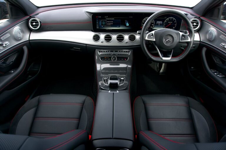 "Professional car upholstery services in Dubai: A skilled technician working on custom leather car seats in a well-equipped workshop, demonstrating precision and expertise in automotive interior design and restoration."