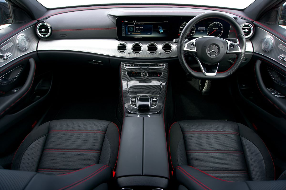 "Professional car upholstery services in Dubai: A skilled technician working on custom leather car seats in a well-equipped workshop, demonstrating precision and expertise in automotive interior design and restoration."